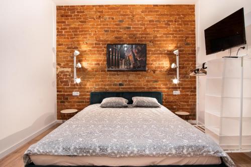 a bedroom with a brick wall and a bed at Dream Aparts - Studio przy Piotrkowskiej in Łódź