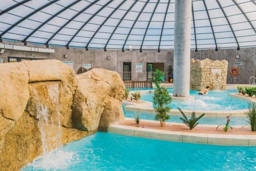 uma piscina com cascata num edifício em Camping Les Garennes em Rang-du-Fliers