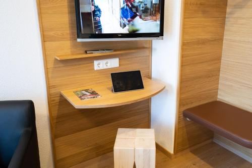 um quarto com uma televisão e um computador portátil sobre uma mesa em Gästehaus Wissler em Todtnau