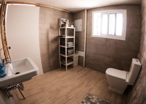 ラスパルマス・デ・グランカナリアにあるLa casa de la playaのバスルーム(洗面台、トイレ付)、窓が備わります。