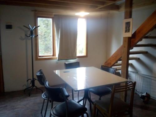 a room with a table and chairs and a staircase at Paisaje Nativo in Villa La Angostura