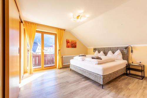 a bedroom with a bed and a large window at Haus Pitzer/Apartments Troicher in Schladming