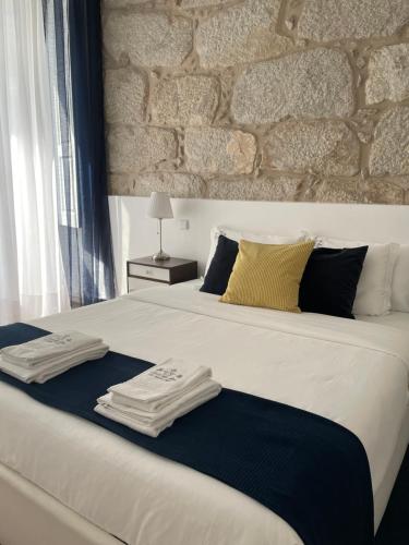 een slaapkamer met een groot bed en 2 handdoeken bij Casa da Ana in Porto