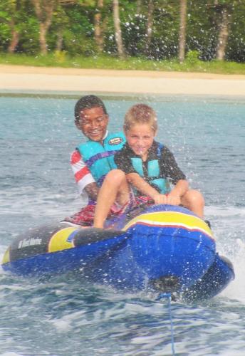 two children riding on a raft in the water at Paraiso Beach Hotel in Big Corn Island