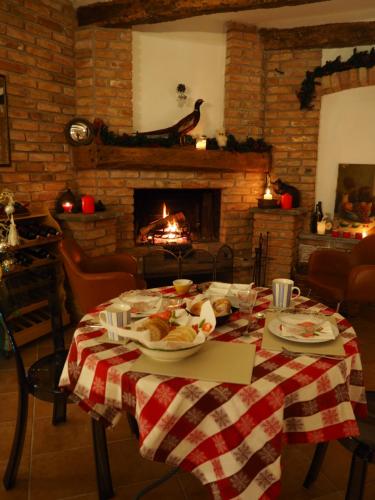 una mesa con un plato de comida y una chimenea en Casa del Roseto, en Belveglio