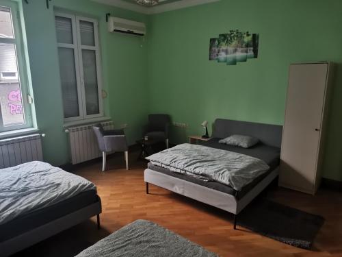 a bedroom with two beds and a table and a chair at Cozy palace in Belgrade