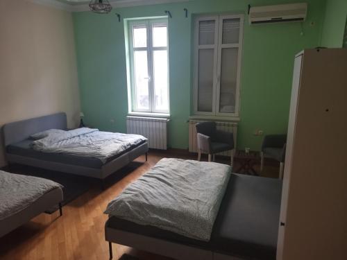 a room with two beds and a window at Cozy palace in Belgrade