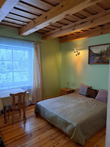 a bedroom with a large bed and a window at Trakai Village apartments in Jovariškės