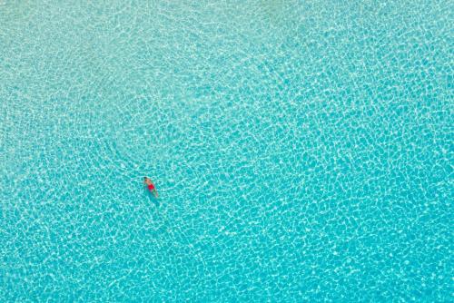 an overhead view of a person swimming in the water at Flora Maisonettes 1 in Gaios