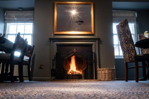 a living room with a fireplace with a picture above it at The Hawes Inn by Innkeeper's Collection in Queensferry