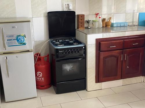 a kitchen with a stove and a refrigerator at Kim luxury apartment in Kampala