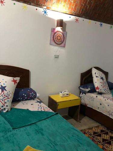 a bedroom with a bed and a table and a lamp at Wesy Ka Guest House in Aswan