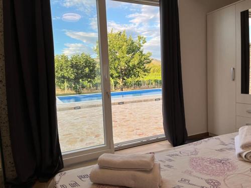 een slaapkamer met een raam met uitzicht op een zwembad bij Adria App Šibenik in Šibenik