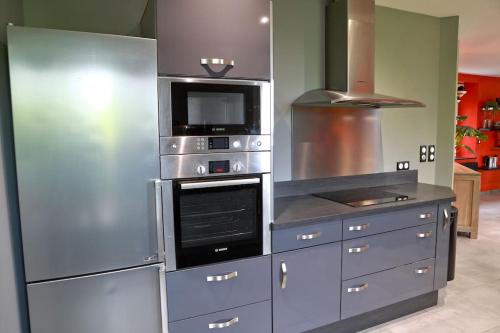 a kitchen with stainless steel appliances in a kitchen at Gîte des Zèbres Aventuriers... in L'Etang-Bertrand