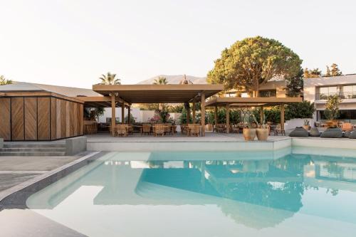 a swimming pool with a patio and a house at Phāea Cretan Malia, a Member of Design Hotels in Malia