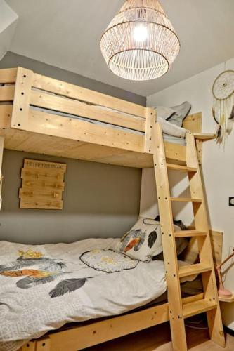a bedroom with a bunk bed and a chandelier at Gîte des Zèbres Aventuriers... in L'Etang-Bertrand