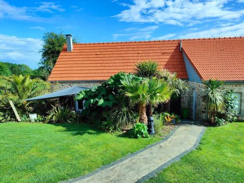 a house with an orange roof and some palm trees at Gîte des Zèbres Aventuriers... in L'Etang-Bertrand