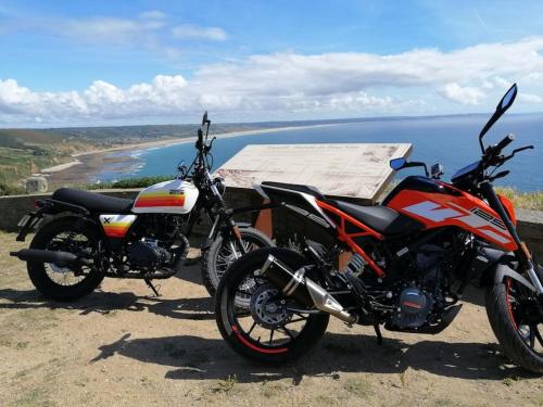 two motorcycles parked on a hill near the ocean at Gîte des Zèbres Aventuriers... in L'Etang-Bertrand
