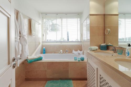 een grote badkamer met een bad en een wastafel bij Duplex Penthouse in Rio Real Golf, Marbella in Marbella
