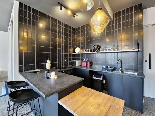 a kitchen with a counter and some black tiles at 9th floor views, couples dream- wifi-pool in Cape Town