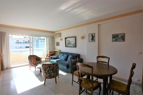 un salon avec un canapé bleu et une table dans l'établissement Appartement 80 m2 au centre-ville de Cannes, à Cannes