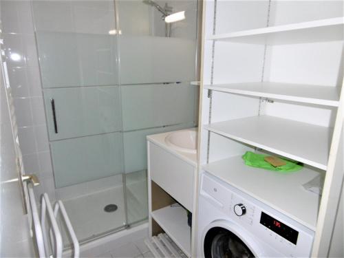 a white bathroom with a shower and a washing machine at Appartment Erwan in Arzon