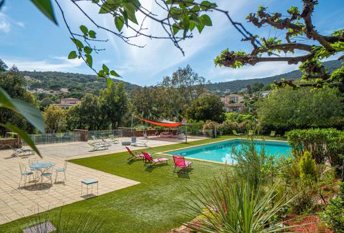 un jardin avec une piscine et des chaises dans l'établissement La villa Roméo, piscine et spa, à Sainte-Maxime