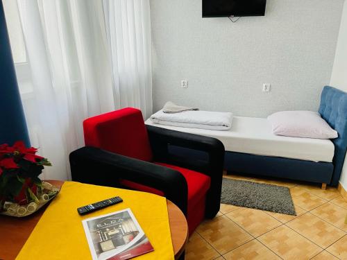a room with a bed and a chair and a table at Hotel Elda in Bydgoszcz