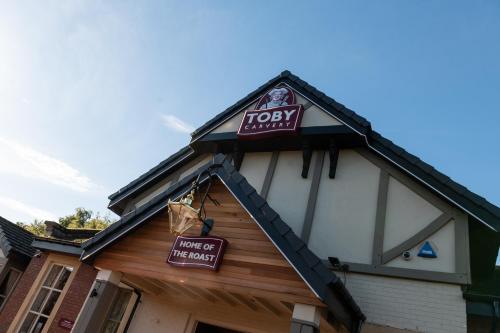 un bâtiment avec un panneau sur son côté dans l'établissement Toby Carvery Strathclyde, M74 J6 by Innkeeper's Collection, à Motherwell