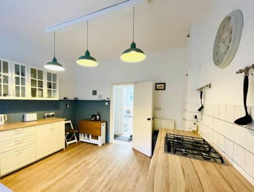 eine große Küche mit weißen Schränken und Holzböden in der Unterkunft Palmerston House with Sea and Downs Views in Ventnor