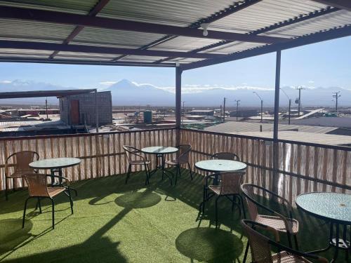 a patio with tables and chairs and a view of mountains at HOSTAL SAIRI in San Pedro de Atacama