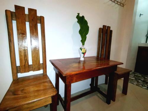 una mesa con un jarrón junto a dos sillas en LADY GHAGHA ROOM RENTALs, en San Vicente