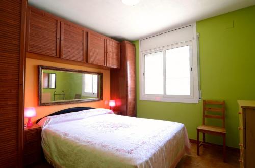 um quarto com uma cama, um espelho e uma janela em BONAMAR Bxs 3 em L'Estartit