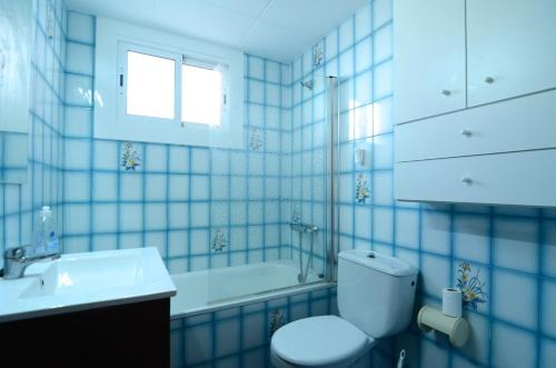 uma casa de banho em azulejos azuis com um WC e um lavatório em BONAMAR Bxs 3 em L'Estartit