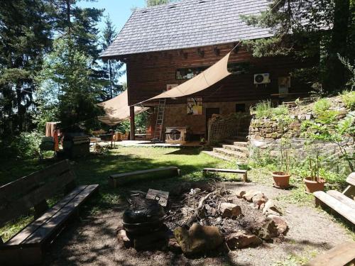 uma cabana de madeira com uma fogueira à sua frente em Mountain Lodge Azzy, surrounded by Ultimate Peace! em Valasské Klobouky