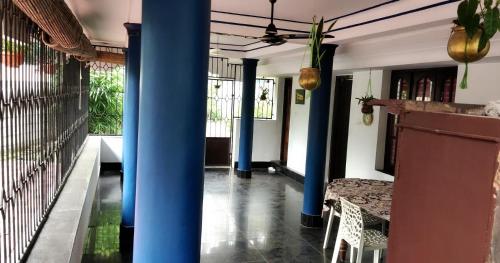 a room with blue columns and a table and chairs at Annie's Villa in Kovalam
