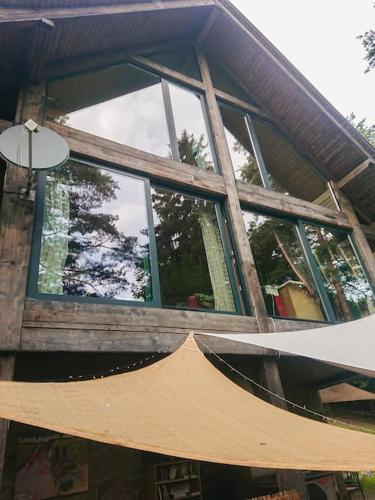 a large window on a house with a hammock outside at Mountain Lodge Azzy, surrounded by Ultimate Peace! in Valašské Klobouky