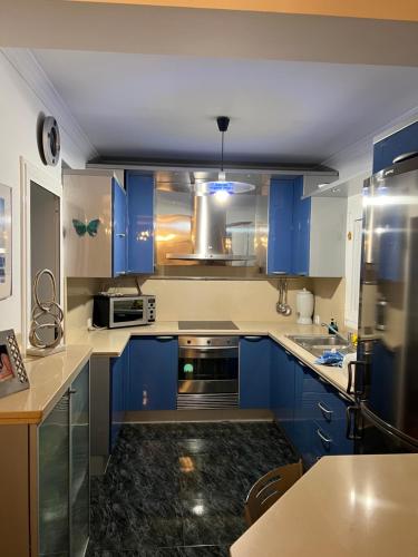 a kitchen with blue cabinets and a stove top oven at COCO in Puerto del Rosario