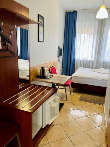 a room with two beds and a desk in it at Hotel Elda in Bydgoszcz