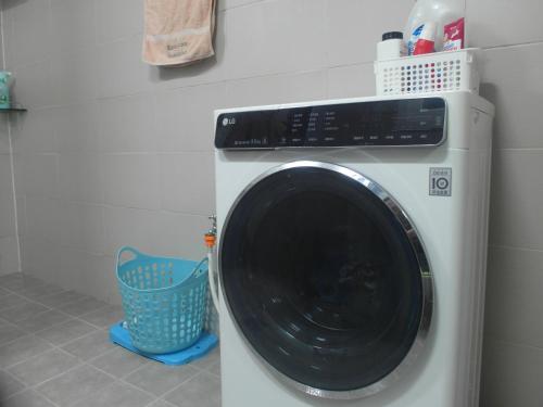 a washing machine in a laundry room with a basket at kbook9 in Seoul