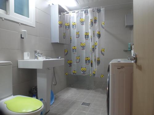 a bathroom with a shower curtain with a toilet and a sink at kbook9 in Seoul