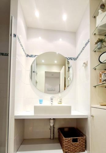 une salle de bain avec un lavabo et un miroir dans l'établissement SUPERBE APPARTEMENT VUE MER - PLAGE, PISCINE et TENNIS PRIVE, à Bandol