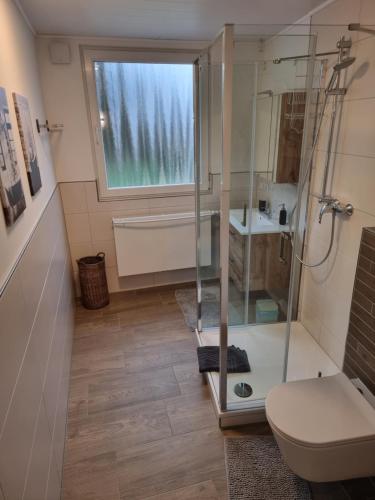 a bathroom with a shower and a toilet and a window at Gästehaus-Ferienwohnung-Appartement mit Terrasse - Nähe Kliniken/ Herzzentrum in Bad Oeynhausen