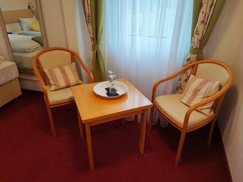 um quarto com duas cadeiras, uma mesa e uma cama em Room in BB - Pension Forelle - double room em Forbach