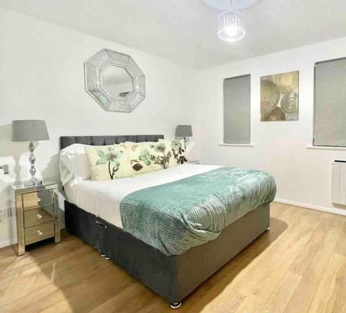 a bedroom with a large bed and a mirror at Skyline Views - Spacious Flat near Cutty Sark & Greenwich with parking in London