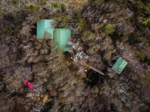 Vue de tête de trois bâtiments verts dans une forêt dans l'établissement Refugio con la Mejor Vista de la Patagonia Chilena, à Villa Cerro Castillo