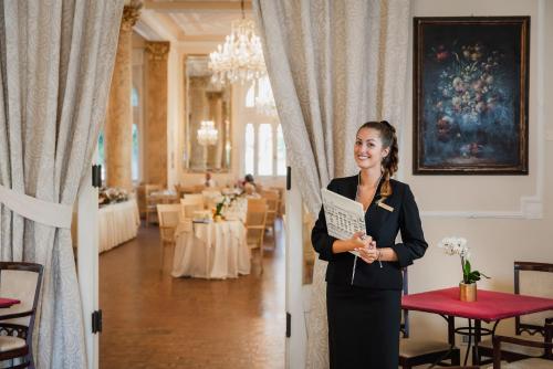 Grand Hotel Rimini في ريميني: امرأة في بدلة تقف في غرفة