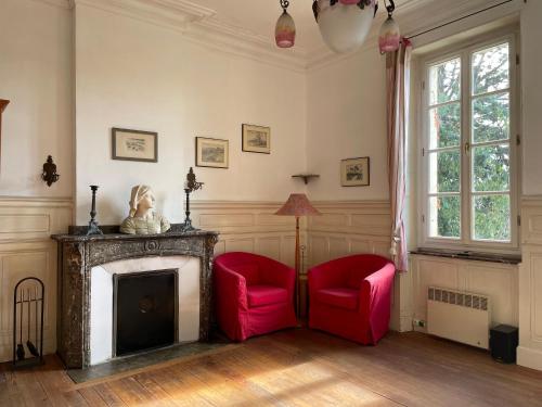 - un salon avec deux chaises rouges et une cheminée dans l'établissement Große Ferienwohnung am Canal du MIDI mit Dachterrrasse, à Homps