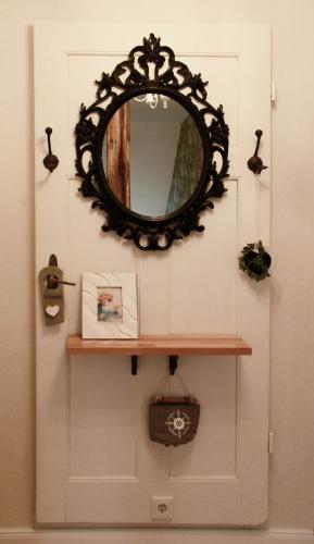 a mirror on a wall next to a door at Petite Maison in Püttlingen