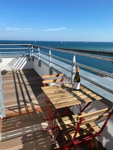 a picnic table with a bottle of wine on the deck of a ship at Penthouse Hygge Meerblick am Strand in Olpenitz